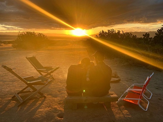 Tim enjoying the view of a sunset with his wife and son